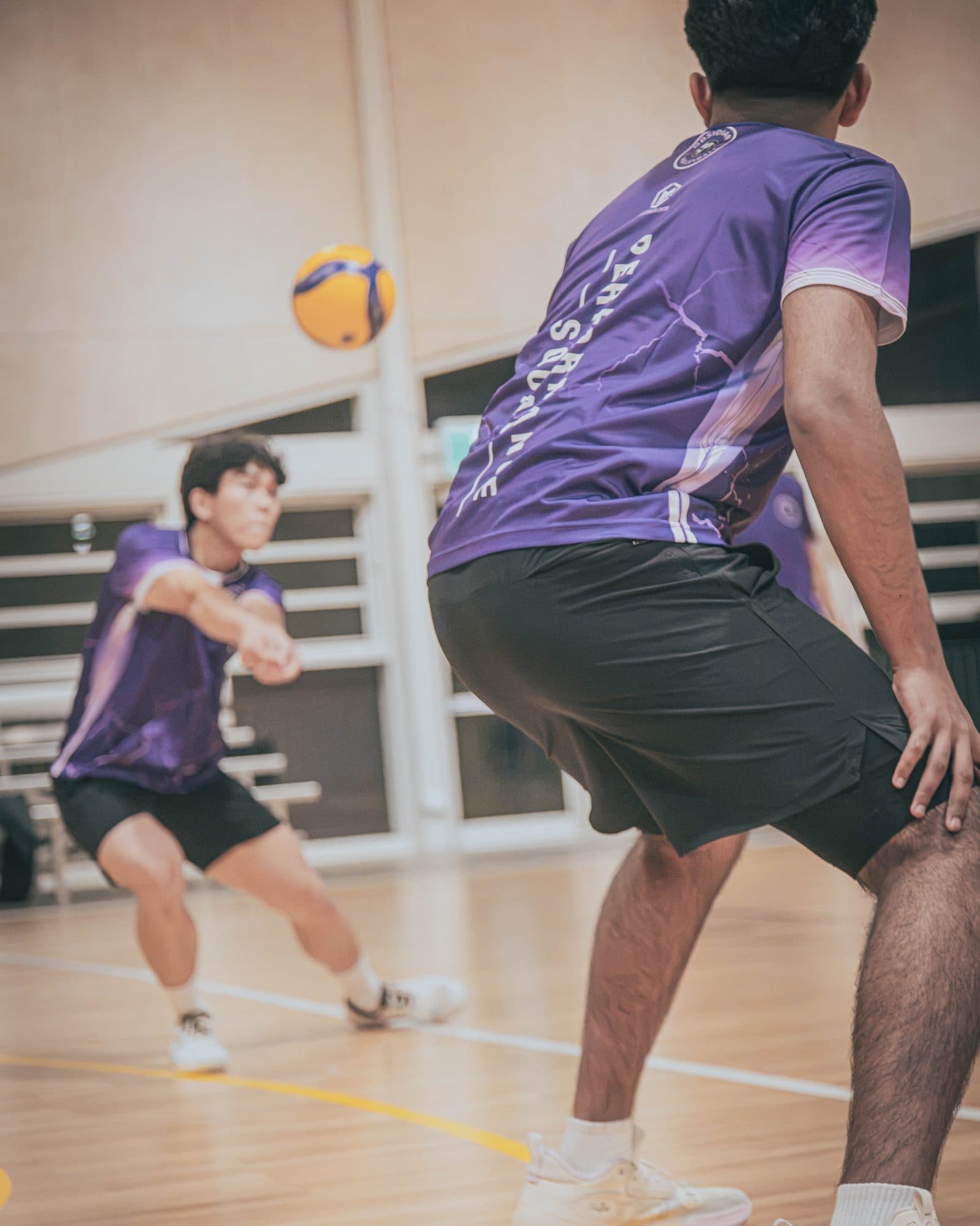 Performance Squad player in a purple Obsidian shirt digging a volleyball at West Ryde
