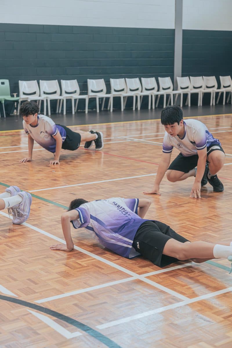 Junior players doing push-ups on the court during a warm-up